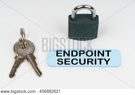 The Concept Of Security In Business. On A White Surface There Is A Lock, Keys And A Blue Sign With T