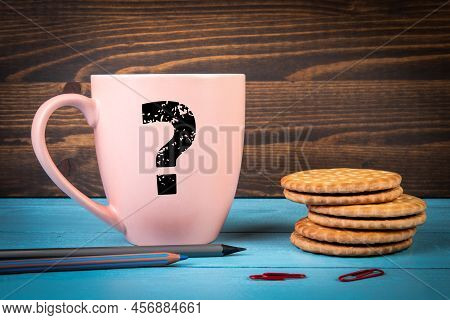 Question Mark On A Pink Coffee Mug. Blue And Black Wooden Background