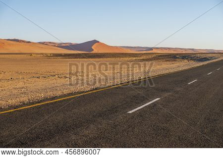 Red Sand Dunes Landscape With Highway Surface On Foregroud In Namibia