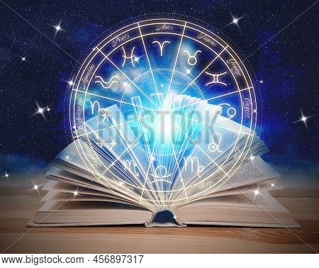 Open Book On Wooden Table, Illustration Of Zodiac Wheel With Astrological Signs And Starry Sky At Ni