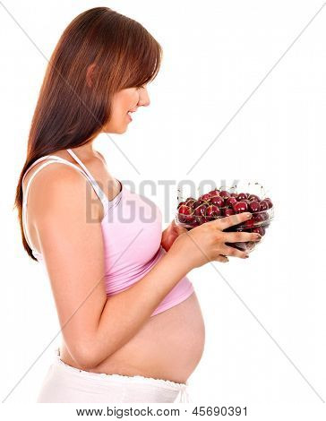 Donna incinta mangiando frutta. Isolato.