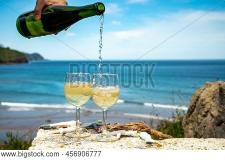 Pouring Of Txakoli Or Chacolí Slightly Sparkling Very Dry White Wine Produced In The Spanish Basque