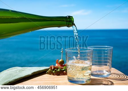 Pouring Of Txakoli Or Chacolí Slightly Sparkling Very Dry White Wine Produced In The Spanish Basque