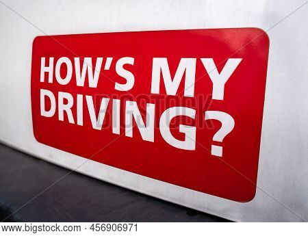 A How's My Driving? Sticker On The Rear Of A Van Or Truck