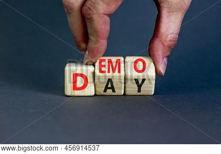 Demo Day Symbol. Concept Words Demo Day On Wooden Cubes. Businessman Hand. Beautiful Grey Table Grey