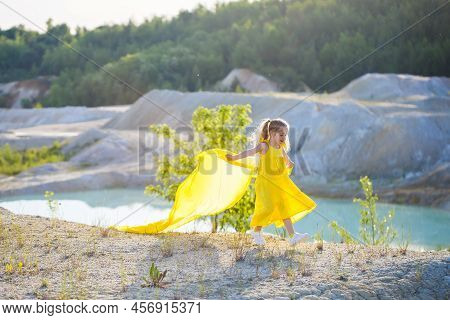 Ukrainian Girl 7 Years Old, She Is A Patriot Of Ukraine, Dressed In A Yellow Dress Against A Blue Sk