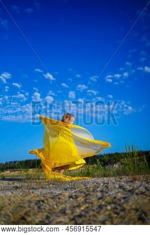 The Symbol Of Freedom Is A Ukrainian Girl Of 7 Years Old, Patriotically Dressed In A Yellow Dress Ag
