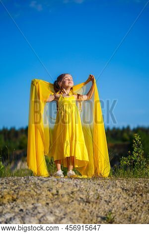 The Symbol Of Freedom Is A Ukrainian Girl Of 7 Years Old, Patriotically Dressed In A Yellow Dress Ag