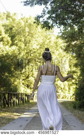 Vertical View Of Unrecognizable Young Brunette Woman Dancing Into The Nature Whearing White Dress