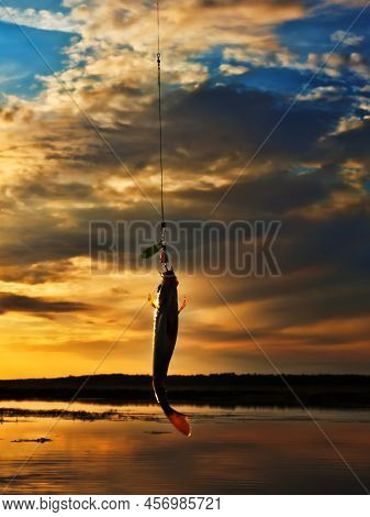 Fishing At Sunset. Catching Predatory Fish On Spinning. Sunset Colors On The Water Surface, Sunny Pa