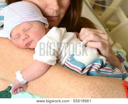 Mother Holding Newborn Infant In Hospital