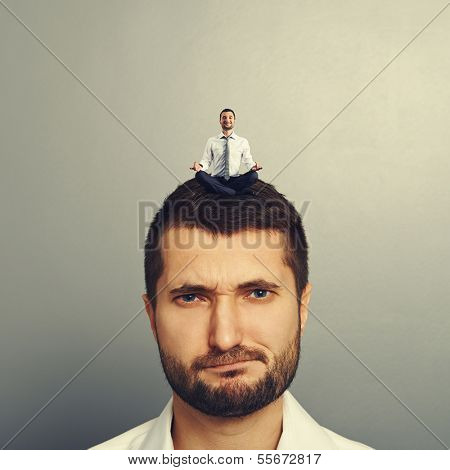 portrait of dissatisfied man with small man on the head