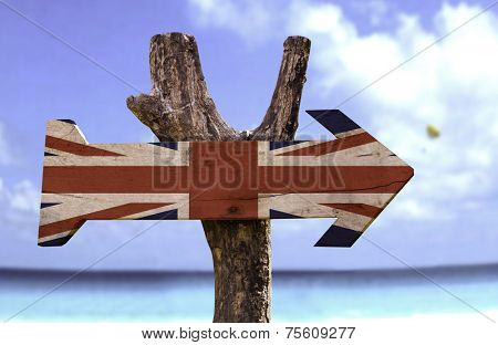 United Kingdom wooden sign with a beach on background 