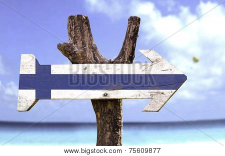 Finland wooden sign with a beach on background 