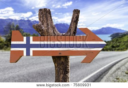 Norway wooden sign with a island on background 