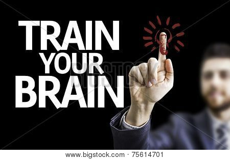 Business man pointing to black board with text: Train your Brain