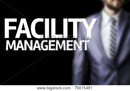 Facility Management written on a board with a business man on background