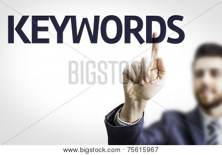 Business man pointing to transparent board with text: Keywords