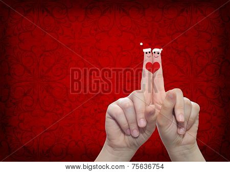 Concept or conceptual old vintage red pattern paper background with man and woman finger in love with Christmas hats and a heart painted, metaphor to family, couple, celebration, holiday, roamnce card