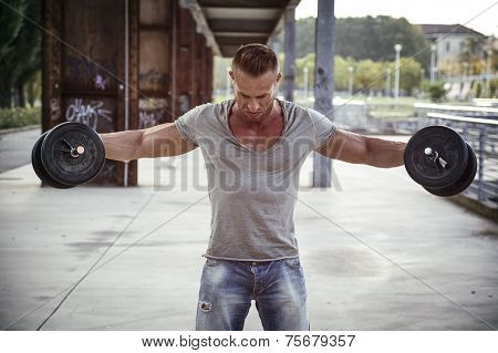 Attractive Muscular Hunk Man Lifting Weights Outdoor