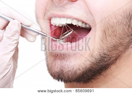Examine of young man by dentist closeup