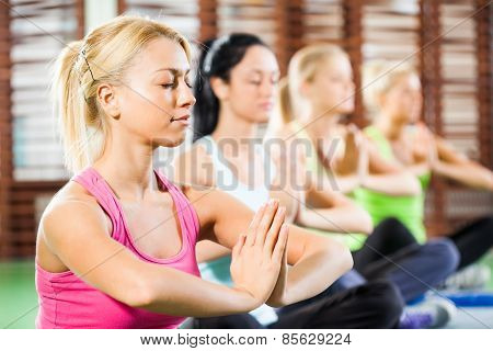 Practicing yoga in gym
