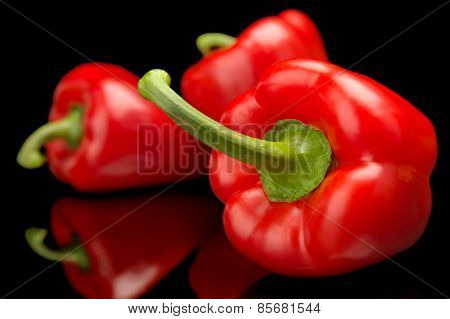 Group Of Red Bell Peppers In The Corner Isolated On Black