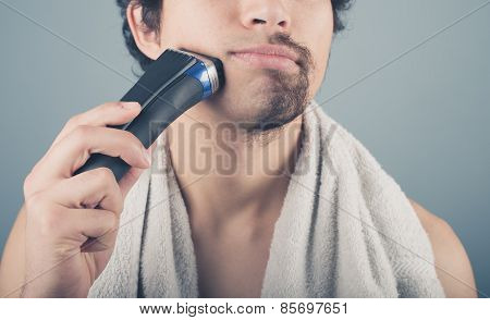 Young Man Shaving Half Of His Beard
