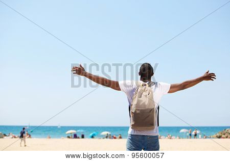 Man Standing With Arms Spread Open At Beach