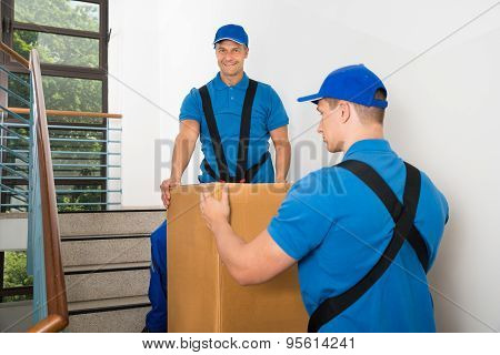 Two Movers Standing With Box On Staircase