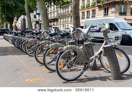Streetview With Woman Paying For Renting A Bycicle In Paris