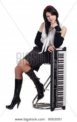 Belle fille assise avec synthétiseur isolé