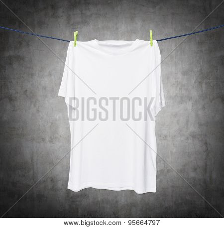 Close Up Of A White T-shirt On The Rope. Concrete Background.