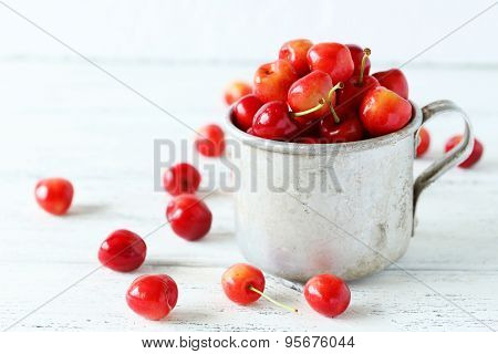 Ripe Cherry In Cup On White Wooden Background