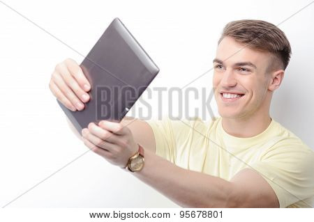 Smiling man holding tablet in front of him
