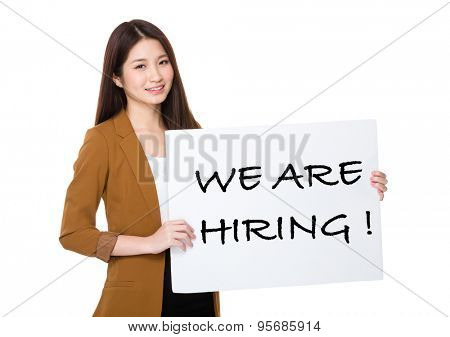 Businesswoman hold with palcard and presenting phrase of we are hiring  