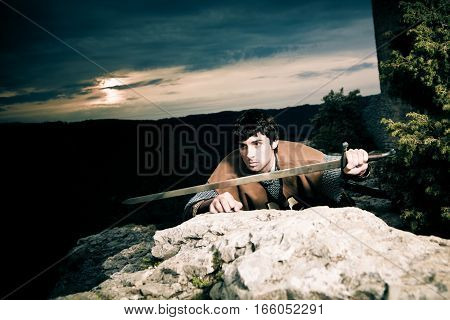 knight posing in front of the ruins of 'burg reussenstein' in southern germany
