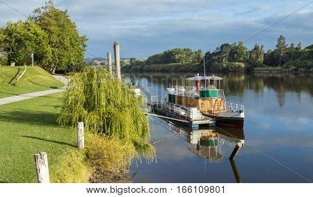 Beautiful morning on the Whanganui river shown a river steam boat.