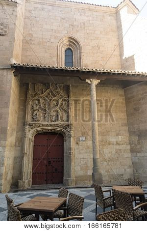 Salamanca (Castilla y Leon Spain): historic buildings with tables and chairs of a restaurant on the street. San Benito church.