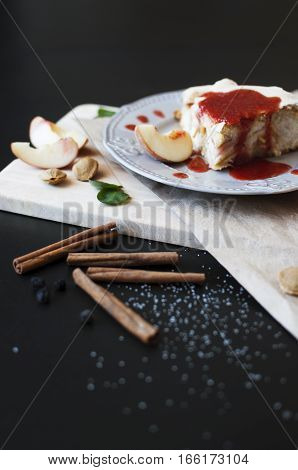 Piece of cake with jam and peaches on a dark wooden table. Pie Baking Cinnamon Peach Jam