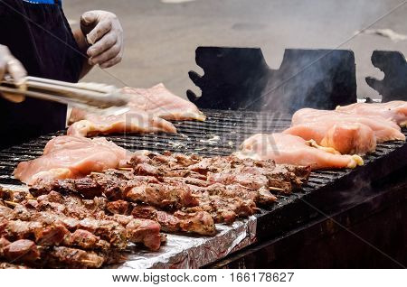 Man cooking chicken skewers kebabs on grill