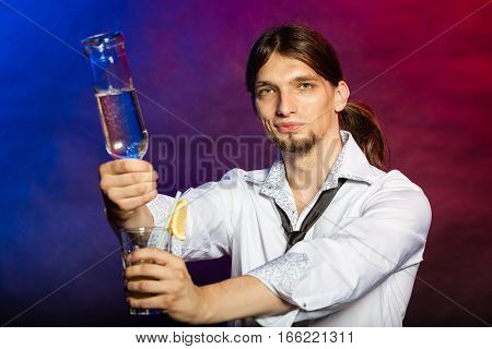 Flair bartending alcohol liquor party concept. Barman showing his skills. Young male tapster makes cocktail.