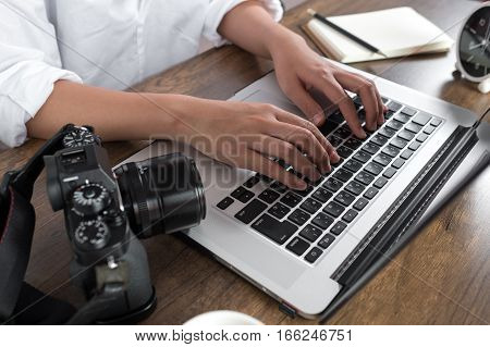 Photographer editing photos on laptop. Studio work, photo service concept. Workplace