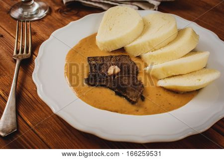 Czech cuisine beef tenderloin and dumplings sauce from vegetables and cream