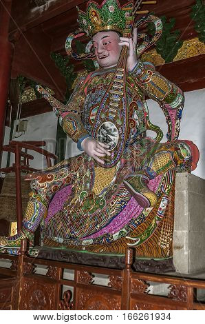 China Hangzhou. Monastery Soul SanctuaryTemple (Lininsy). Hall of Heavenly Rulers sculpture Dhrtarashtra (a lute).