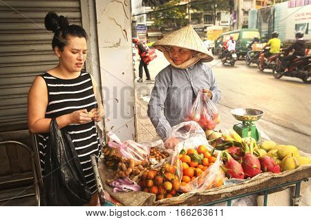 Ho Chi Minh Vietnam Januar 15 2017: Unidentified vietnamese woman bye fruit on market place in Ho Chi Mihn city Vietnam Januar 15 2017.