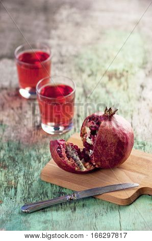 Fresh pomegranate juice and pomegranate. Pomegranate and glass of pomegranate juice on a wooden textural background. Healthy drink