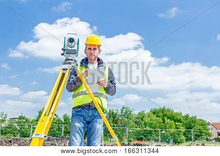 Zrenjanin Vojvodina Serbia - May 25 2015: Surveyor engineer is measuring level on construction site. Surveyors ensure precise measurements before undertaking large construction projects.