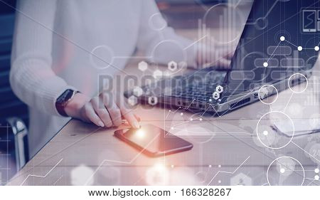Concept of digital screen, virtual connection icon, diagram, graph interfaces.Pensive young beautiful businesswoman using modern mobile phone and laptop while sitting at her working place.Flares