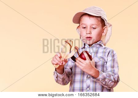 Young Boy Use Sling Shot Shoot Apple.